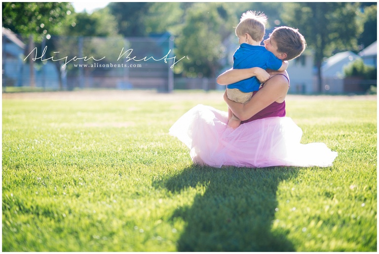 mother in tutu embraces young boy
