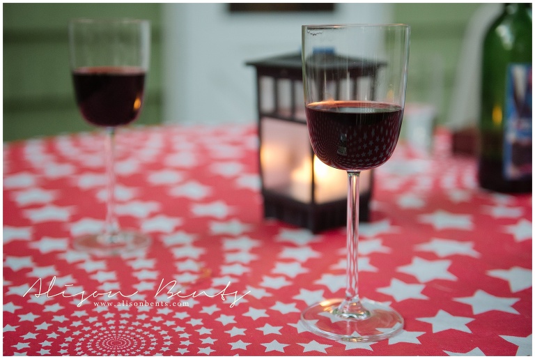 red wine in glasses on picnic table with lantern