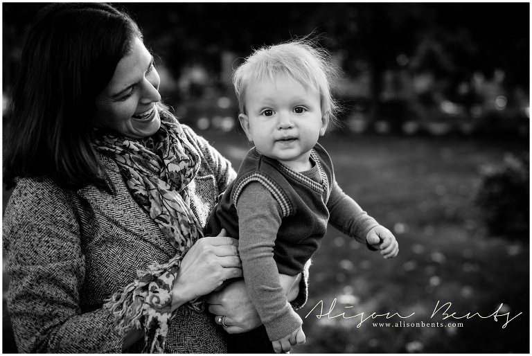 mom holding blonde baby in vest