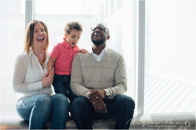 interracial family laughs together on white background | St Paul Family Photographer